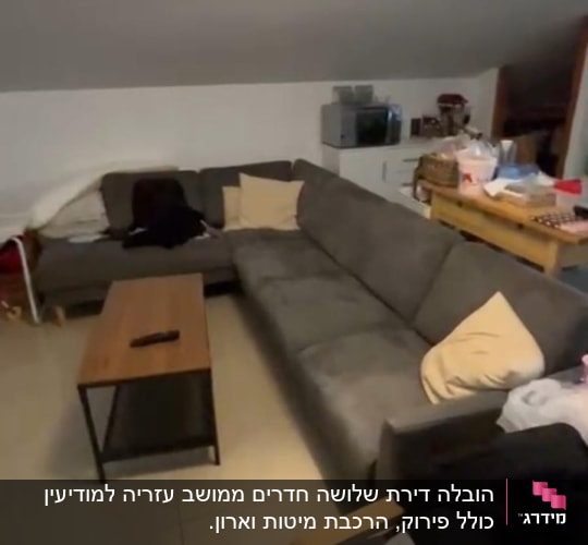 חפצים ארוזים על כורסה, שולחן קטן עם שלט